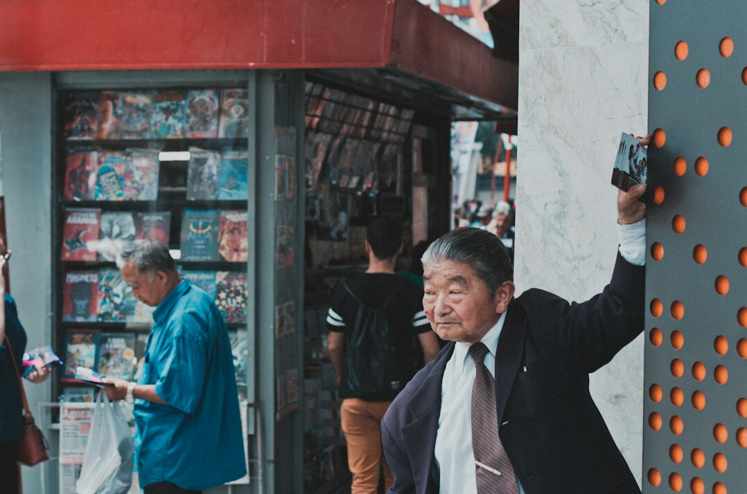 Portrait of a Japanese male photographer holding a camera and smiling