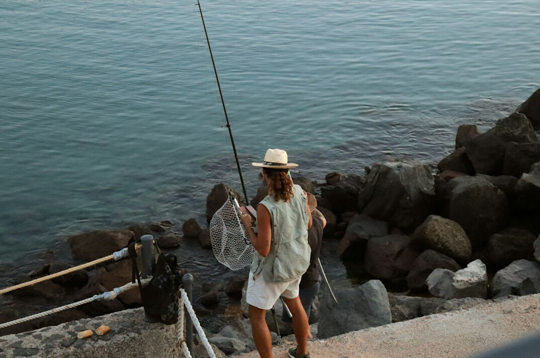 woman fishing by sea
